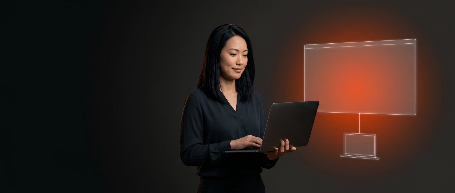 Mulher branca oriental de blusa preta usando um laptop se conecta a uma tela grande, sobre fundo escuro.